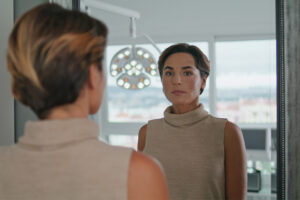 A woman gazes into the mirror, learning that when your caregiving role ends, you may have a variety of emotions to work through.