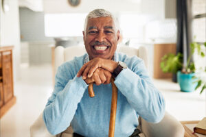 A man who has overcome a fear of falling in older adults leans confidently on his cane.